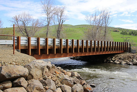 A Big R rolled girder vehicular bridge over a stream.
